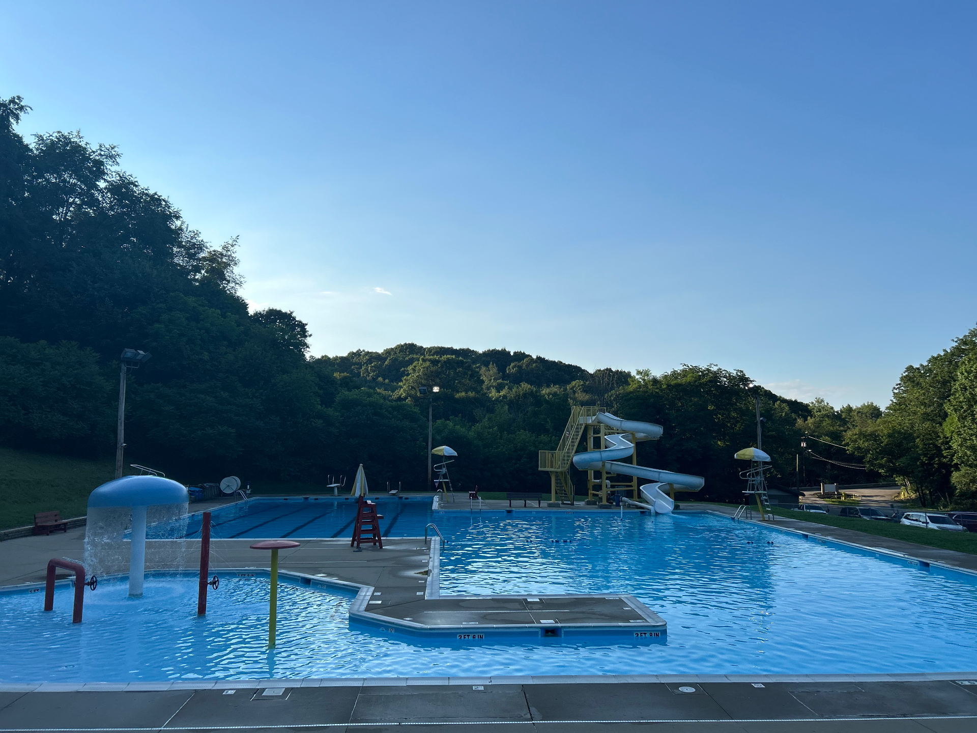 Sunset sky over Petrarca Memorial Pool with the water slide and pool lights